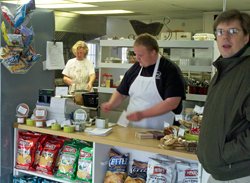 Patty preps as Doug sells a huge cookie to an unidentified customer